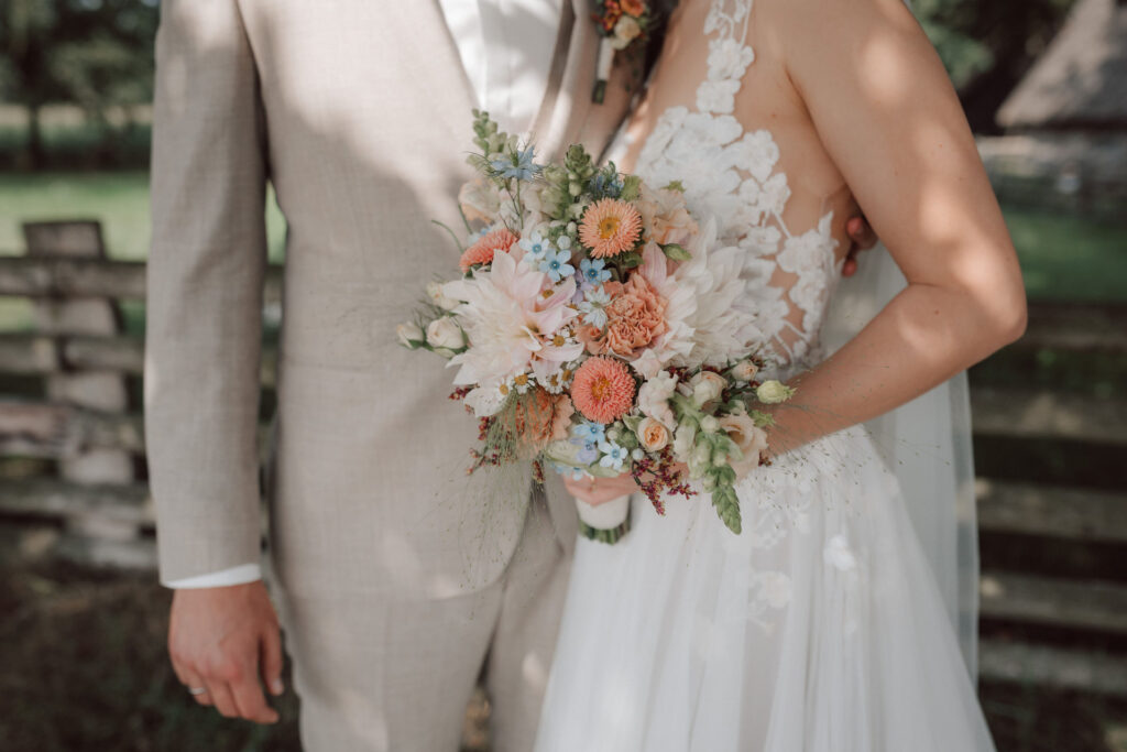 Detailaufnahme des Brautpaares mit pastellfarbenem Brautstrauss waehrend einer Hochzeit auf Gut Horn. Authentische Hochzeitsfotografie und natuerliche Hochzeitsfotos vom Hochzeitsfotograf Oldenburg.