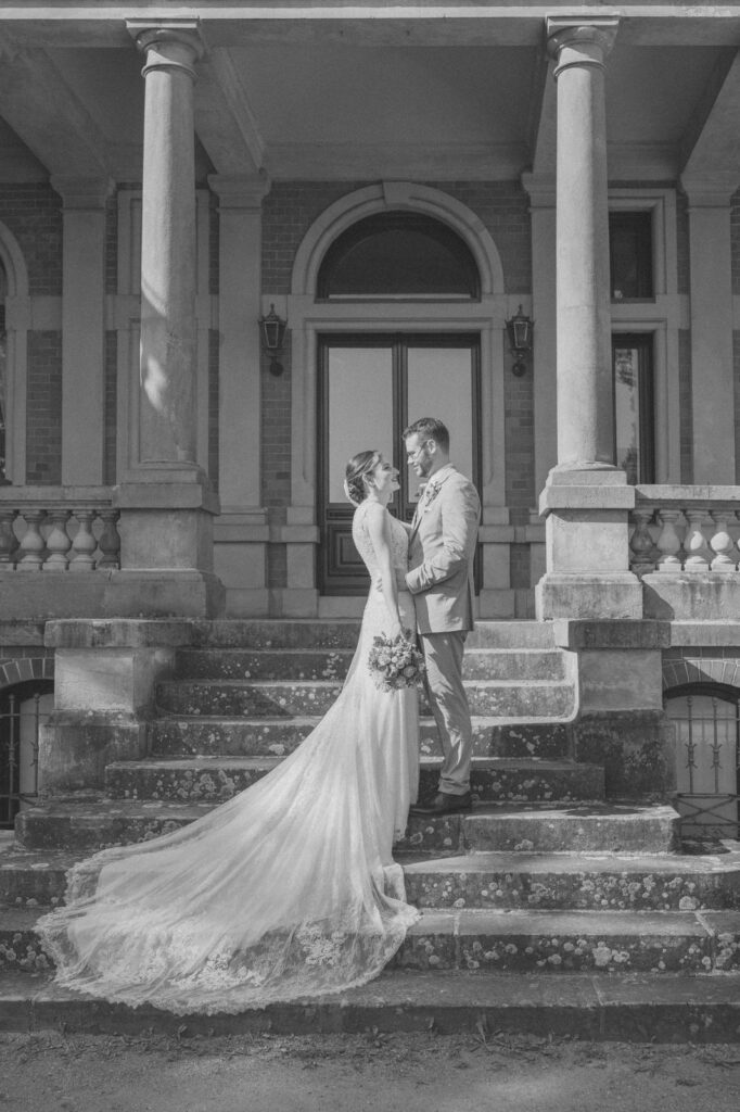 Brautpaar steht auf den Treppen von Gut Wahnbek bei Oldenburg – emotionale Hochzeitsfotos vom Hochzeitsfotograf Oldenburg